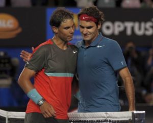 Rafael Nadal (L) of Spain and Roger Federer of Switzerland hug at the net, after Nadal won their men's singles semi-final match at the Australian Open 2014 tennis tournament in Melbourne January 24, 2014. REUTERS/Bobby Yip (AUSTRALIA - Tags: SPORT TENNIS) - RTX17SC8